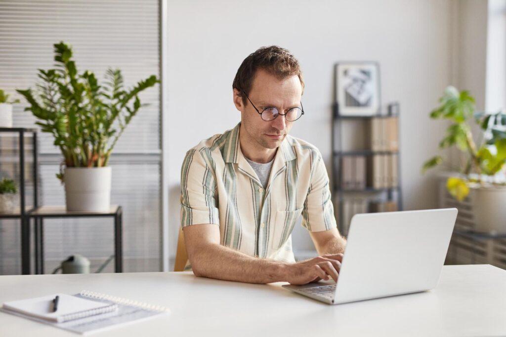 A person working on a laptop at a desk